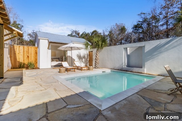 Outdoor private pool with stone water feature and patio seating