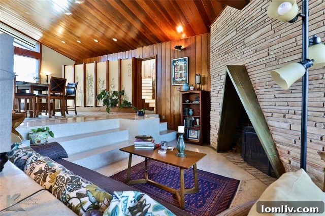 A stunning view of the living room showcasing the unique triangle fireplace and the distinctive ceiling design.