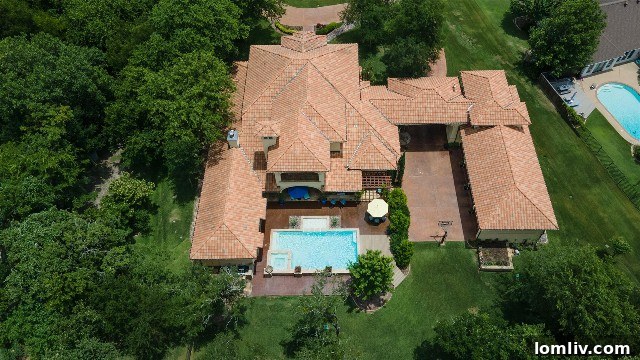 Multi-level clay barrel tile roof and a central courtyard with a water feature, emblematic of Hacienda architecture.