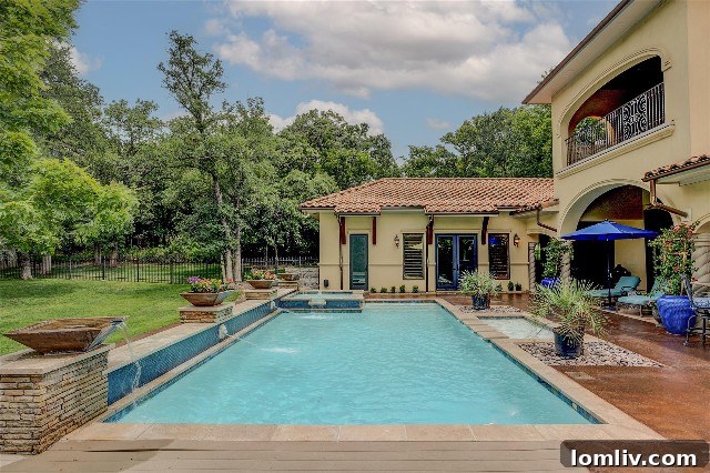 Beautiful swimming pool central to the home at 167 Kortney Drive, surrounded by lush landscaping, typical of Hacienda design.