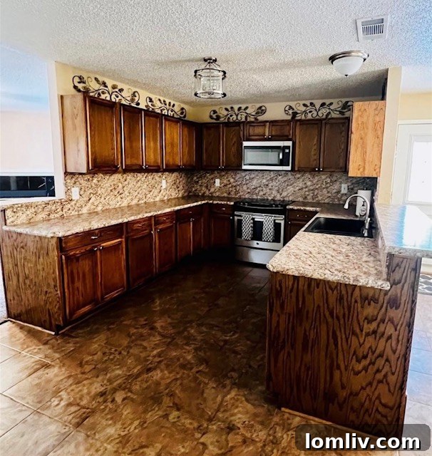 Modern kitchen with white cabinetry and stainless steel appliances.