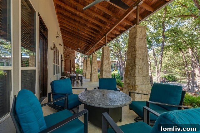 Expansive backyard of 712 Bandit Trail in Keller, featuring abundant shade from mature trees, a pool, and multiple seating areas for relaxation and entertainment