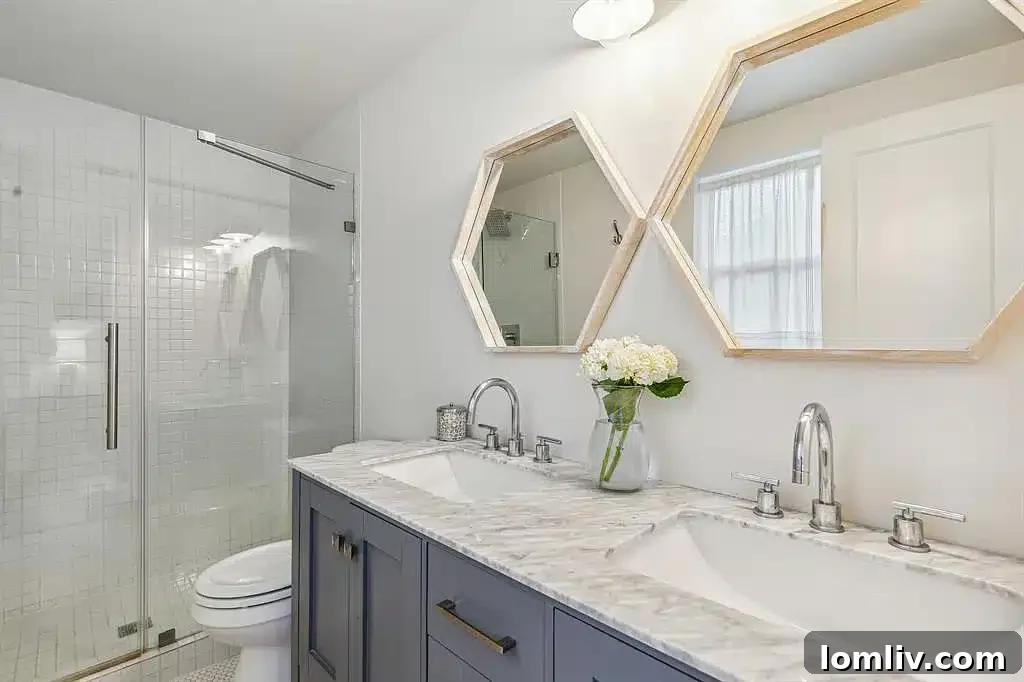 Primary bathroom with dual vanities and modern tilework.