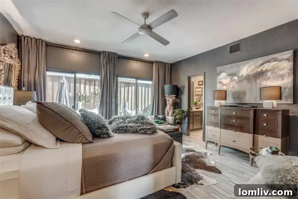 Oaklawn's Oglesby Gem: A Tranquil Escape 4 Spacious primary bedroom with slate gray walls, hardwood floors, and modern furnishings.