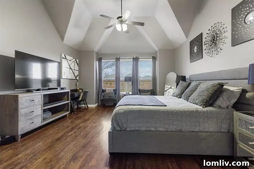 Luxurious master suite with sitting area and bay window, offering comfort and style