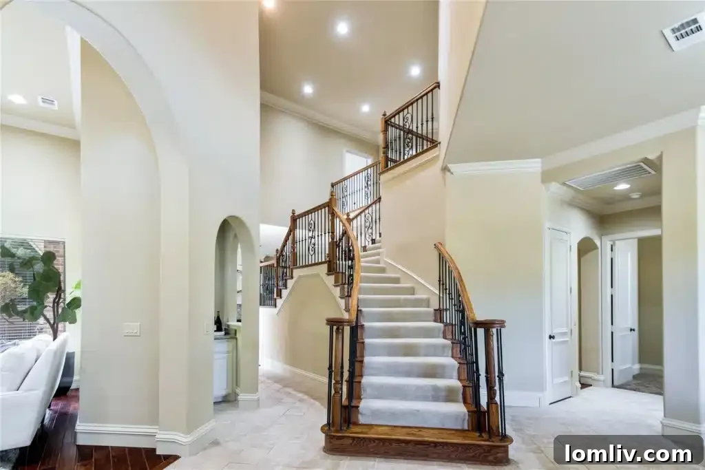 Elegant living room with high ceilings and a grand staircase in a Twin Creeks custom home, Allen TX