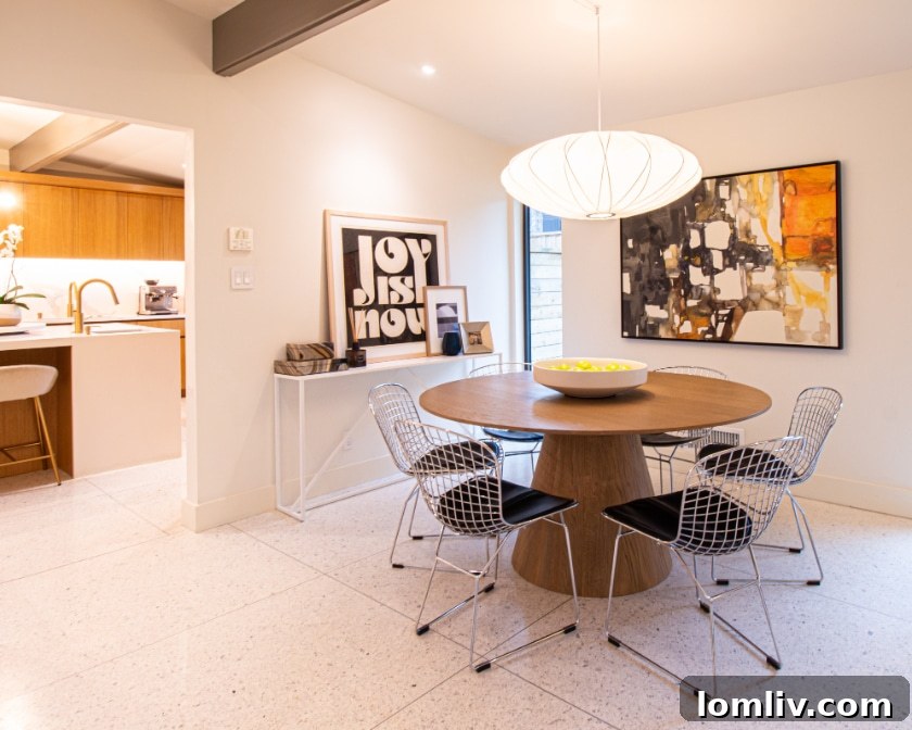 The vibrant orange front door of the Midcentury Modern home, flanked by cream brick and gray board-and-batten siding, creating a striking curb appeal.