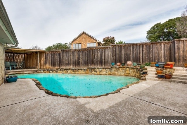 A vibrant pool area with a covered patio, perfect for summer days and entertaining guests at this Merriman Park home.