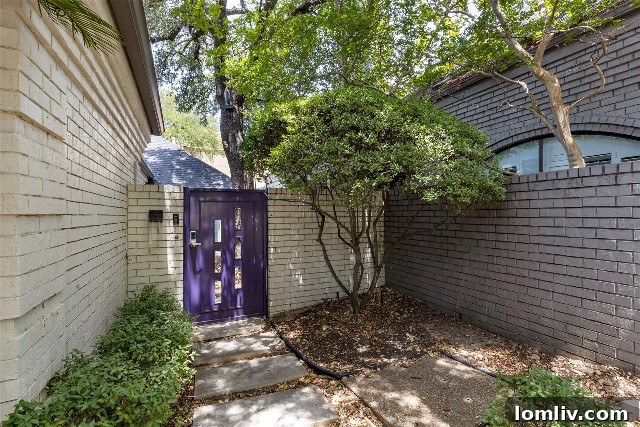 Fort Worth's Rare Single-Level Gem in a Gated Oasis 4 Inviting purple courtyard gate leading to a fully updated luxury townhome