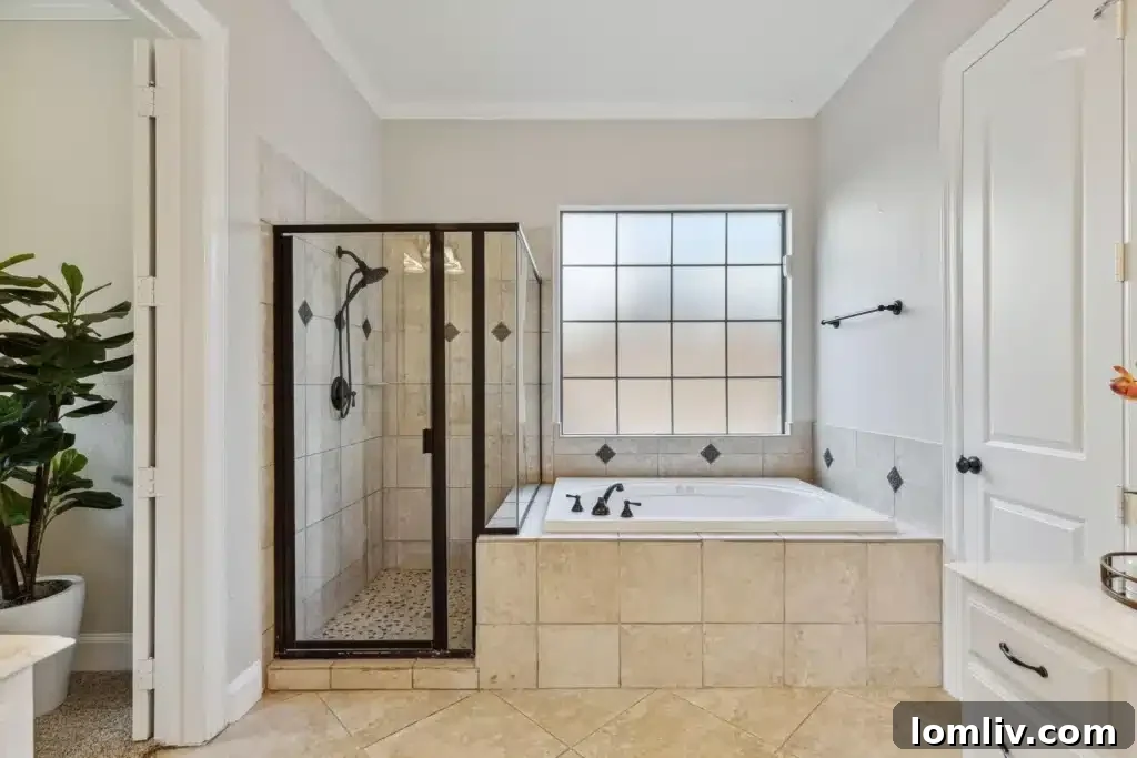 Luxurious primary bathroom with elegant tilework, soaking tub, and dual vanities