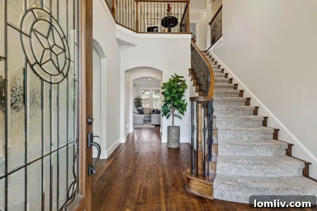 Interior view of the grand iron-post staircase and hardwood floors in the entryway
