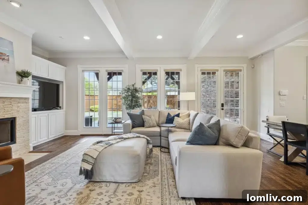 Spacious living room with fireplace, built-in shelving, and large windows
