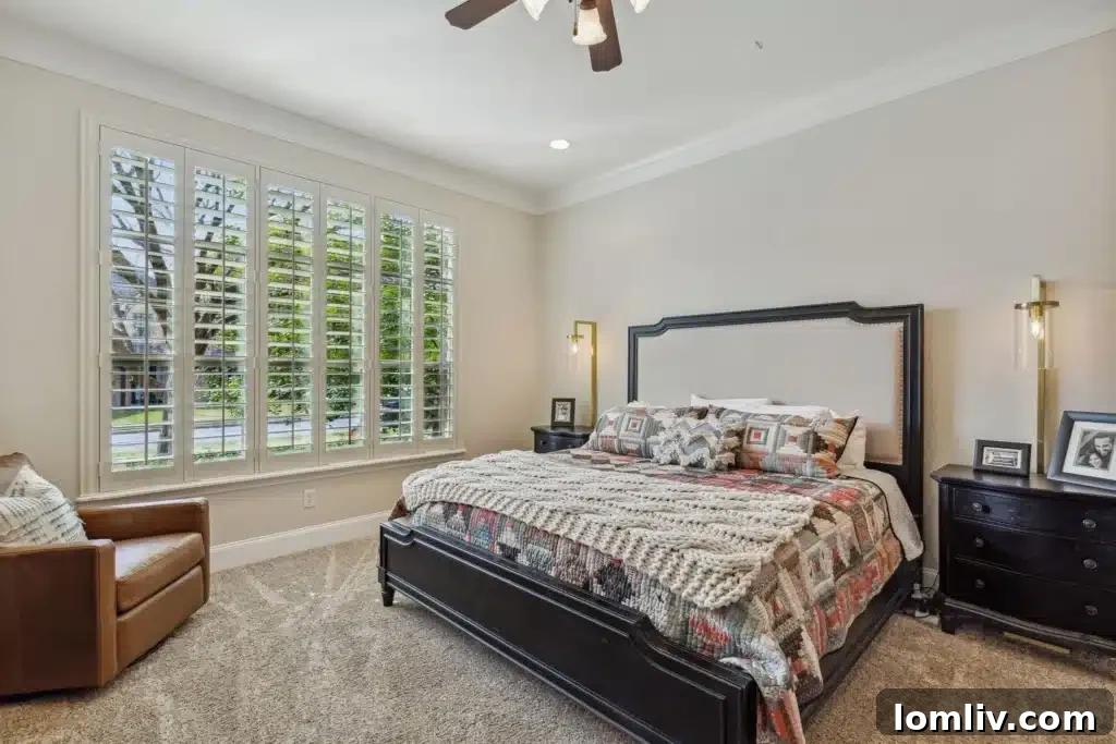 Spacious primary bedroom with large windows and comfortable seating area