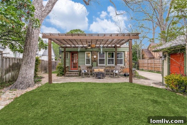 Professionally landscaped backyard featuring a elegant slate pergola over a patio