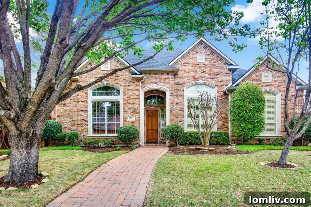 Traditional red brick home with a walkway and large tree in Plano, Texas