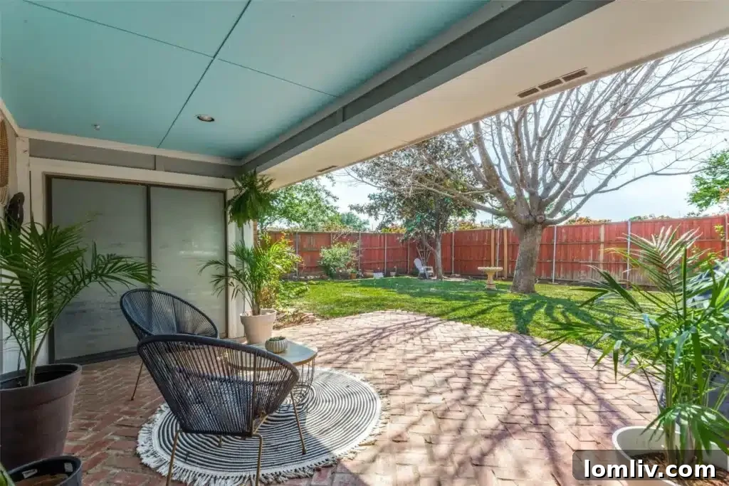 Spacious backyard with a covered patio and large lawn, ideal for family activities