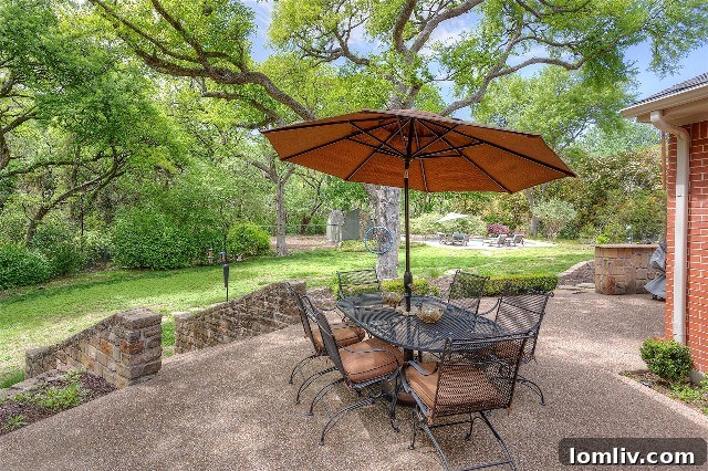 Expansive and private backyard patio at 4132 Tamworth Road, perfect for outdoor dining and relaxation, shaded by a beautiful canopy of mature trees, leading out from the family room.