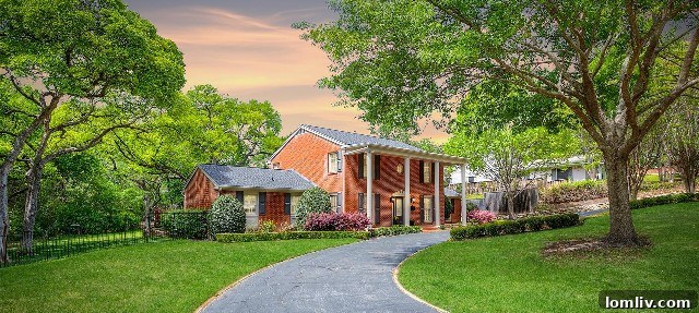 Elegant Colonial architecture of the home at 4132 Tamworth Road, majestically rising amidst a canopy of mature trees, exuding a stately and private presence.