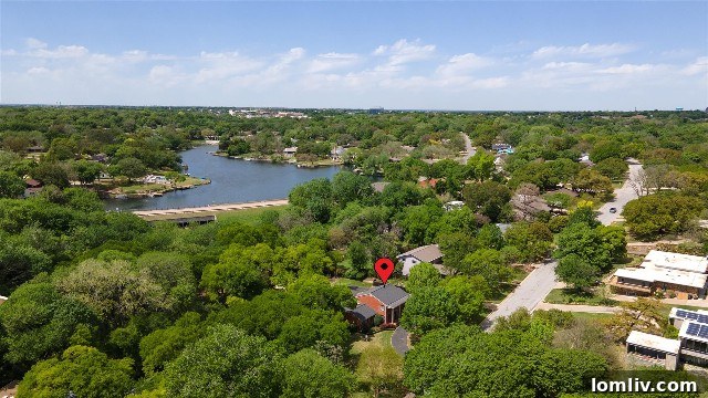 Aerial view of 4132 Tamworth Road in Ridglea Hills, showcasing its expansive tree-lined property and close proximity to the tranquil waters of Luther Lake, emphasizing the home's natural setting.