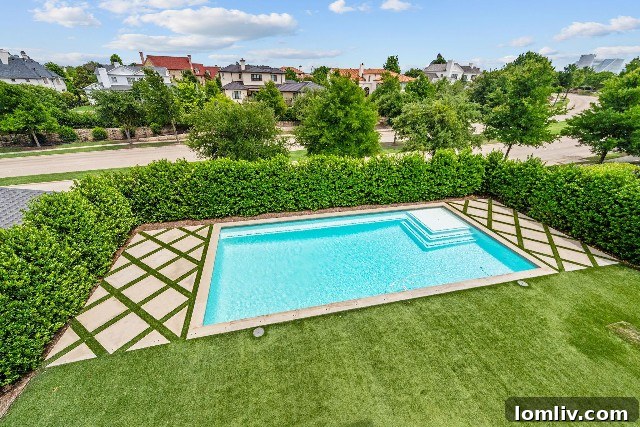 Luxurious backyard oasis with a swimming pool, covered patio, and built-in grill