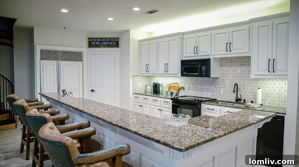 A.J. Foyt's Texas Motor Speedway Penthouse Accelerates Your Life 5 A modern kitchen with granite countertops, stainless steel appliances, and a direct view of a race track.