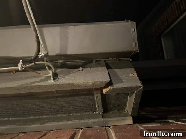 Damaged fascia on a house where wind pulled attached lights away, revealing structural damage.