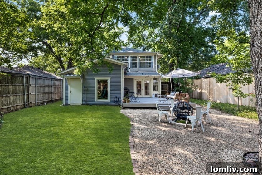 The inviting backyard patio with a fire pit, surrounded by lush landscaping and mature trees, perfect for outdoor living.