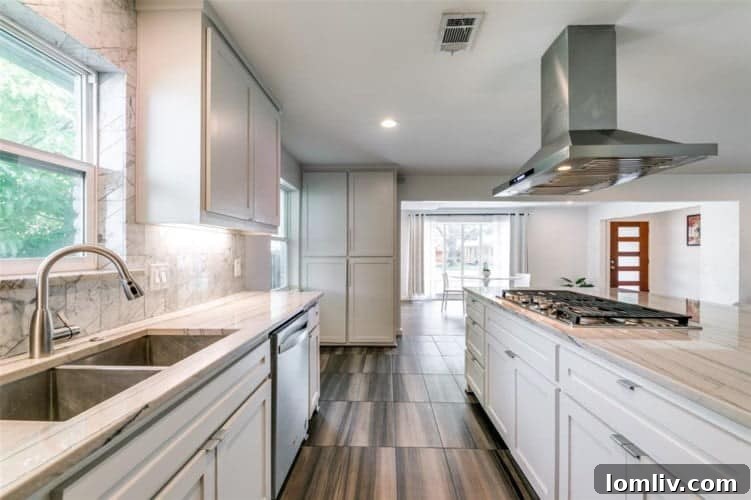 Fully renovated kitchen featuring crisp white cabinetry, new appliances, and ample counter space