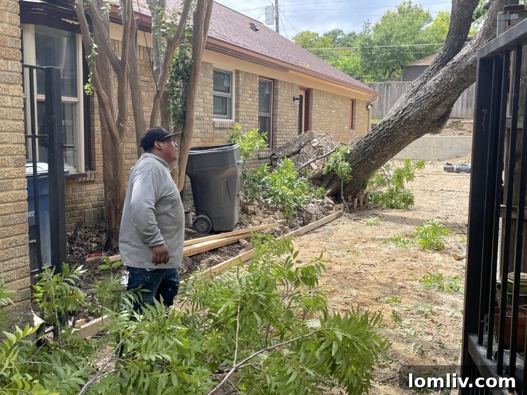 Residential street covered in tree limbs and leaves, indicating significant storm damage.
