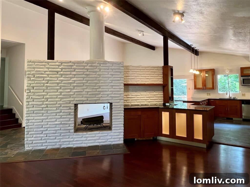 Bright and open concept living area with fireplace and large windows