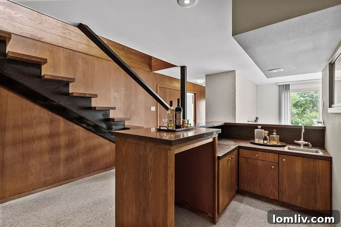 A elegant staircase with warm wood paneling, leading to the lower level of the Fort Worth home.