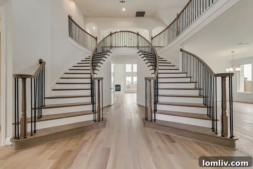 Grand foyer with a stunning dual staircase, showcasing elegant design