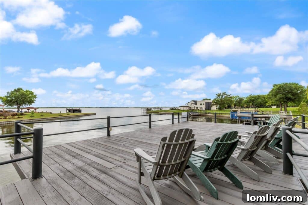 Luxurious boathouse with covered seating and a party deck, overlooking open water.