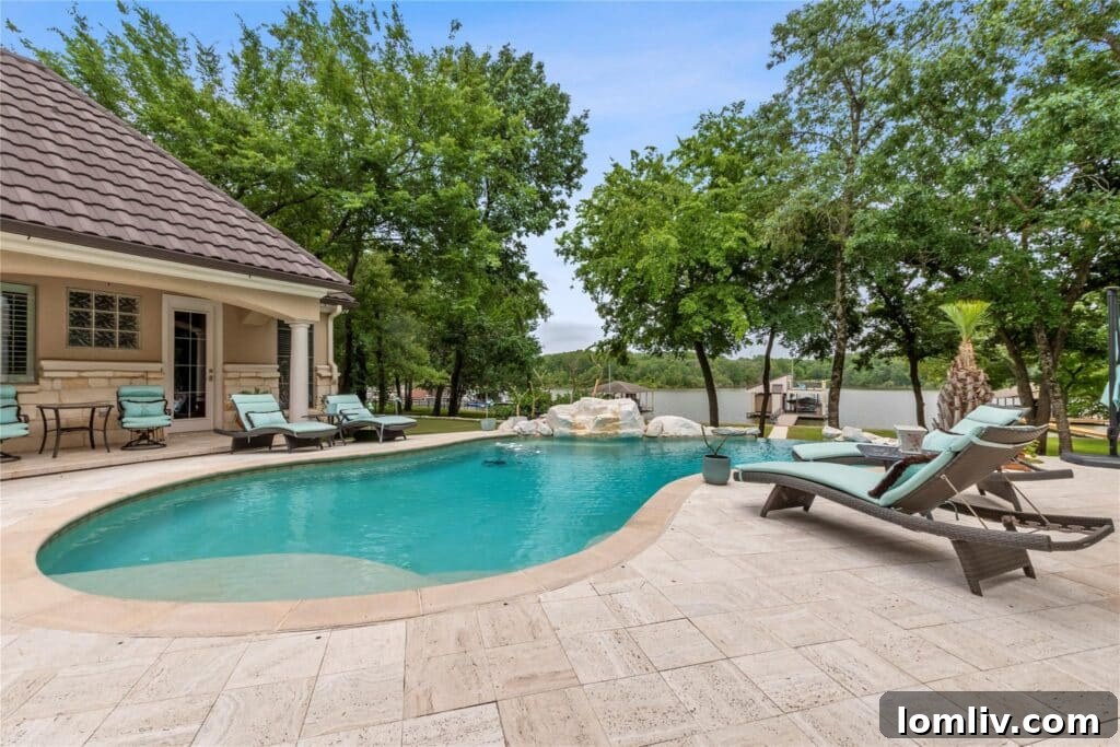 Luxurious primary suite with a fireplace and stunning views of the pool and lake.