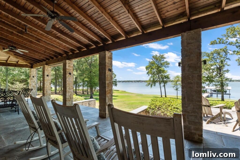 Expansive outdoor entertaining area with a stone fireplace and comfortable seating.