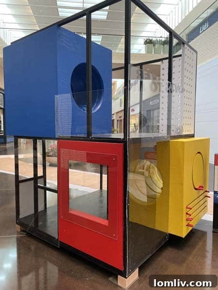 A vibrant, multi-level playhouse inspired by Piet Mondrian's abstract art, featuring primary colored panels and bold black lines, seen from one angle.