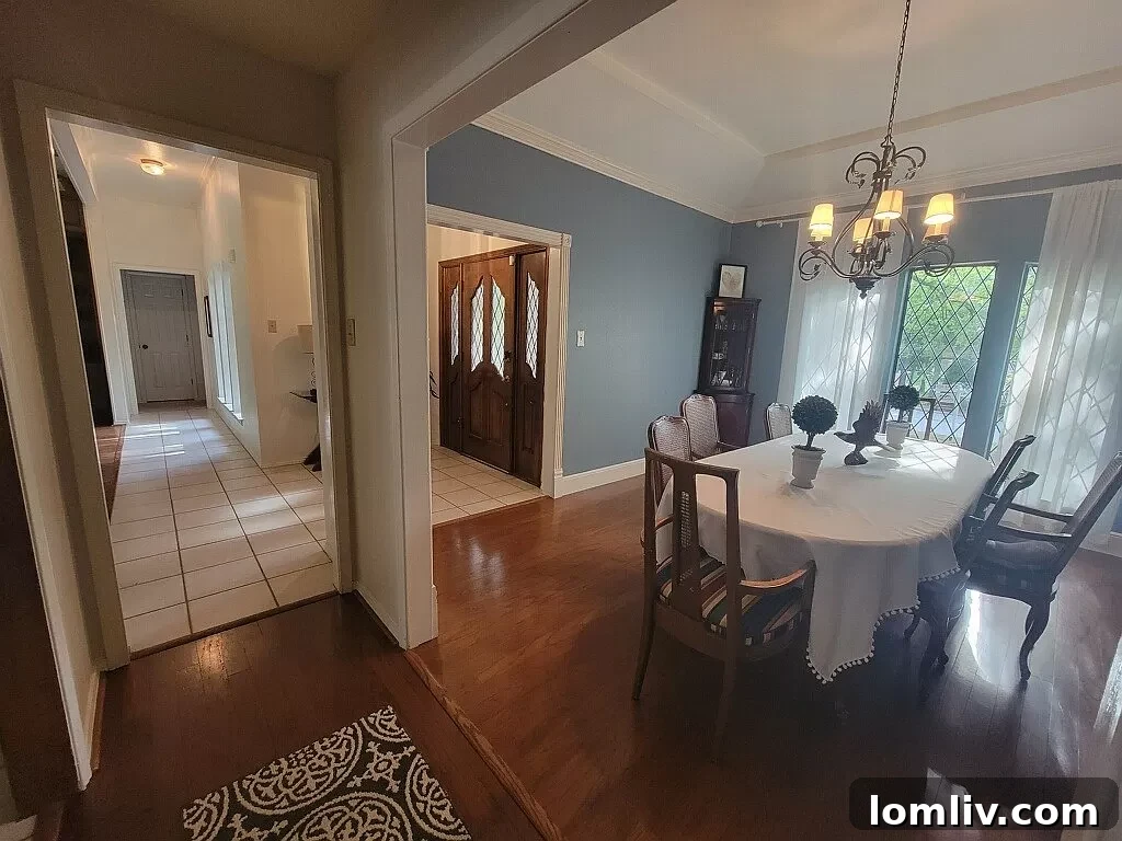 A formal dining room with large windows overlooking trees.