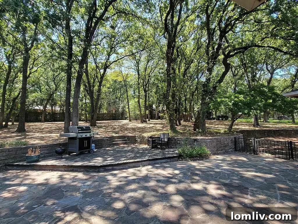 A spacious, park-like backyard with a canopy of trees, ideal for entertaining.