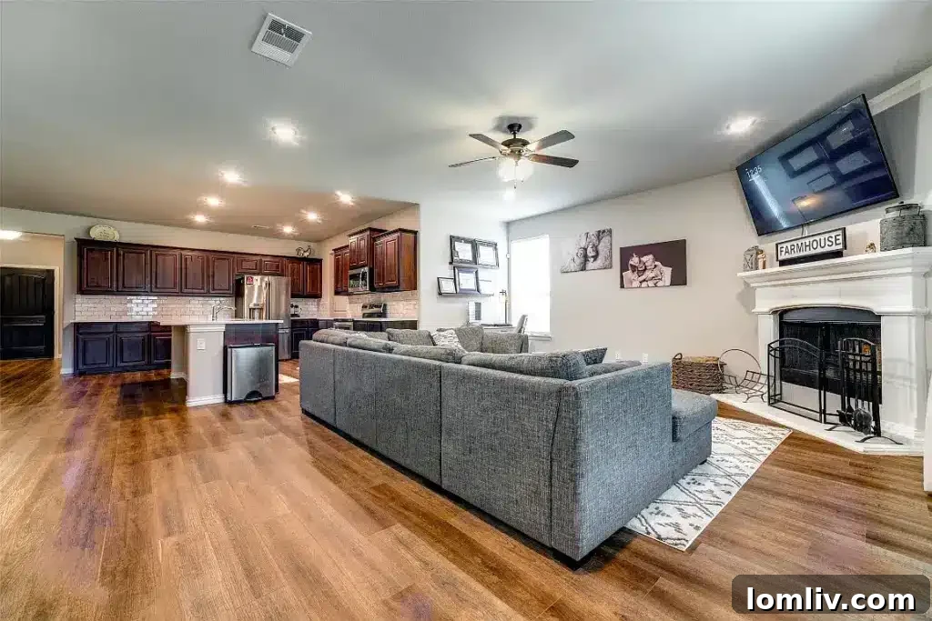 Go West to Springtown: Live the Country Dream on a Budget 5 An inviting living room with a neutral color scheme, a comfortable sofa, a textured rug, and a television mounted above a contemporary fireplace.