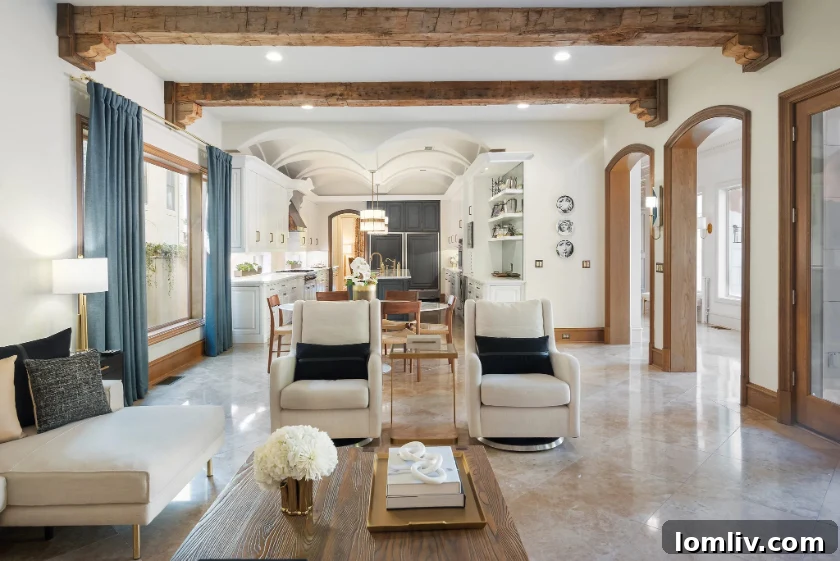 The sophisticated third living area with exposed wooden beams and an impressive cast-stone fireplace, offering views of the pool.