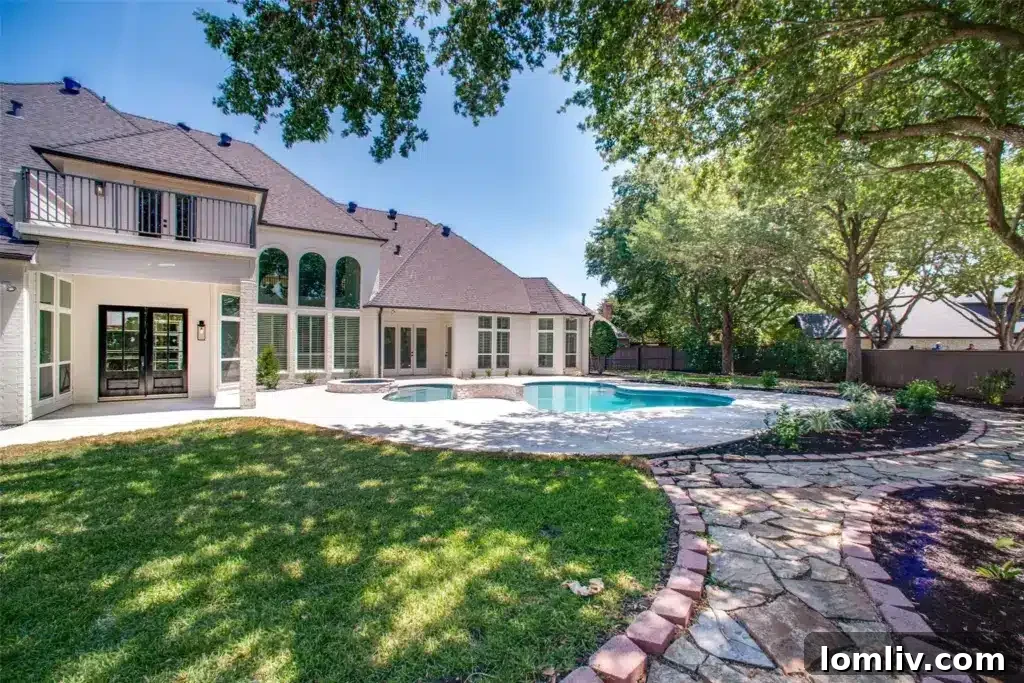 Stunning remodeled pool with new decorative tile, coping, and pebble tech finish in a private backyard oasis