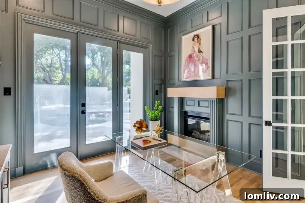 Luxurious executive study with a fireplace, built-in cabinetry, and large windows overlooking the pool