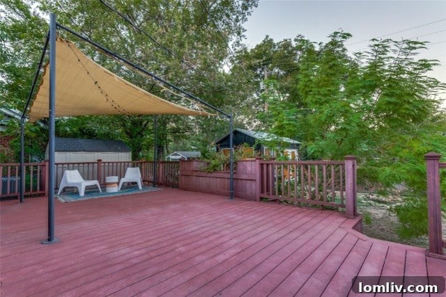 Spacious wooden back porch with a canopy and a separate artist's studio in the backyard