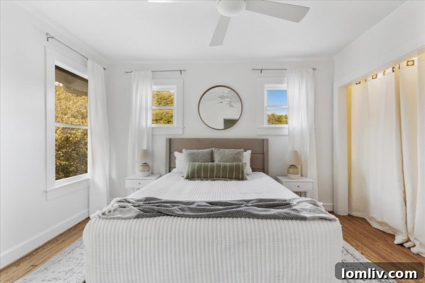 A bright and spacious living area with hardwood floors, modern minimalist decor, and ample natural light, showing the flexible and open layout of the home.