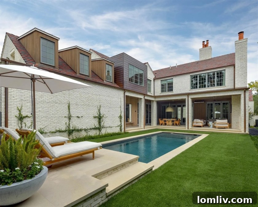 Expansive outdoor loggia leading to a swimming pool and landscaped backyard