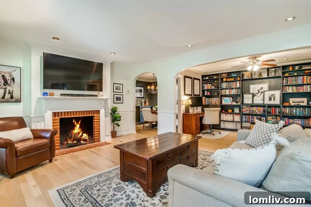 Spacious and inviting living room with new oak hardwoods, wainscoting, and an arched entryway, ready for festive gatherings.