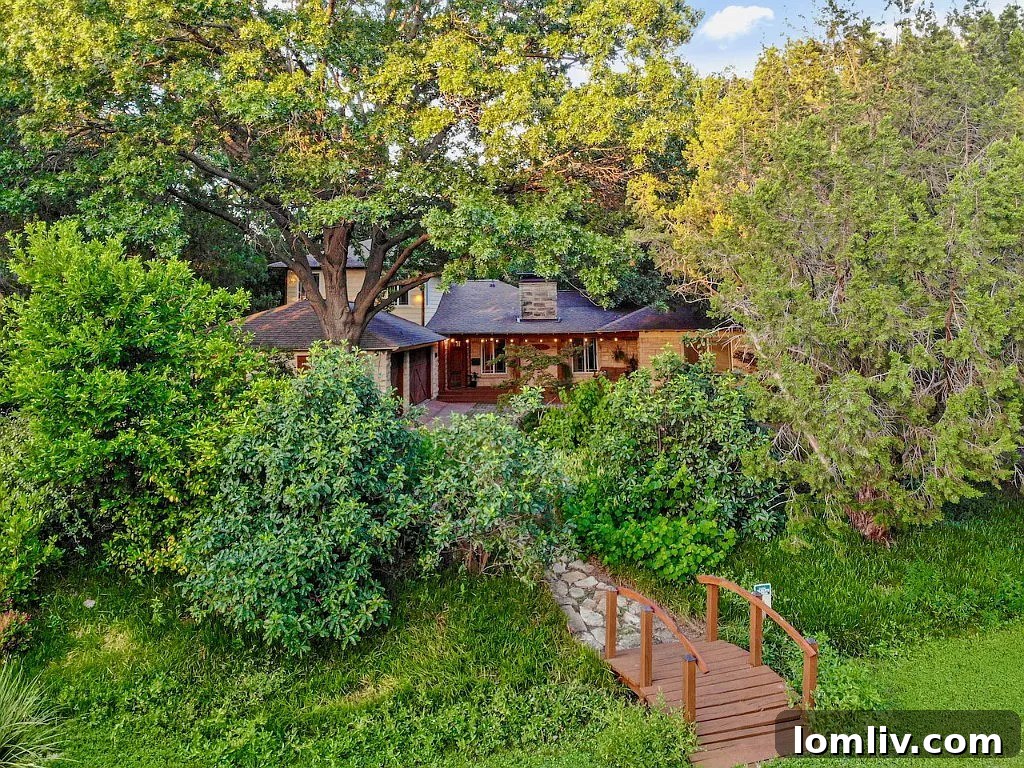 House with extensive natural landscaping, bridge, and rock pathway