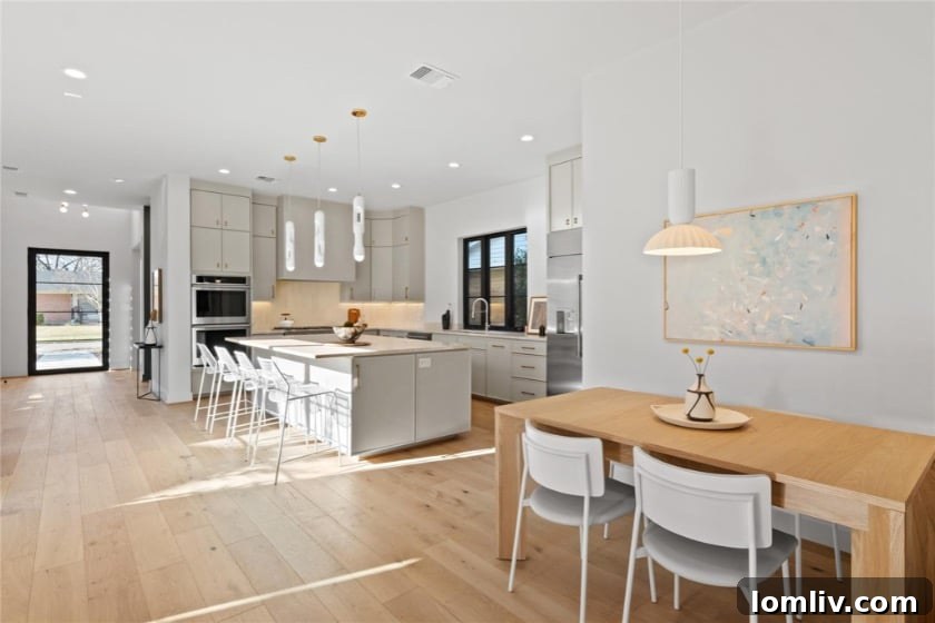 An inviting dining area with contemporary furnishings, large windows, and a sophisticated chandelier, highlighting the elegance of 5West Homes.