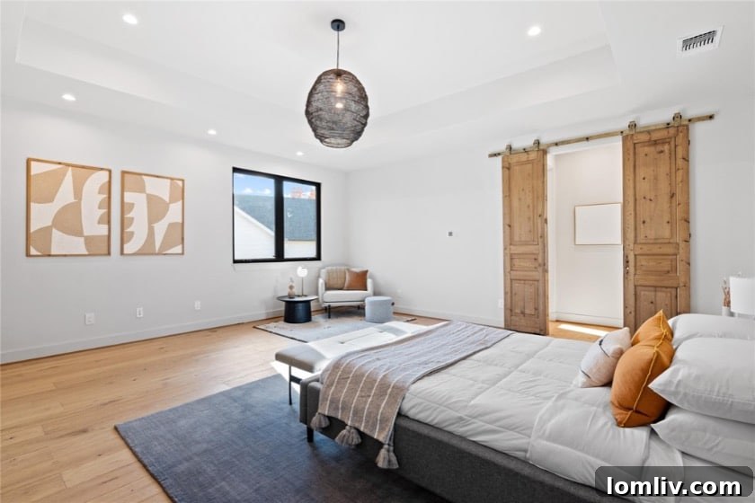 An elegantly styled bedroom with warm neutral tones, a cozy seating area, and tasteful artwork, reflecting 5West Homes' inviting aesthetic.