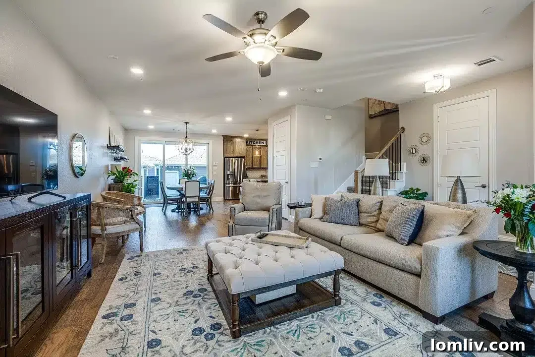 An open living space with a staircase leading to upstairs bedrooms and a loft office, featuring wood flooring.